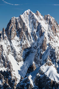 Scenic view of snowcapped mountain against blue sky