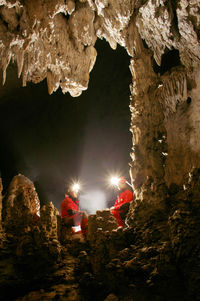 People sitting in illuminated cave