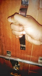 Close-up of hand holding metal door