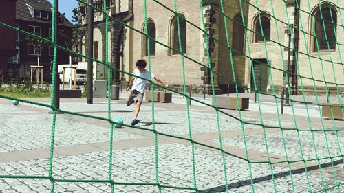 Boy playing football on walkway