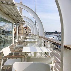 Empty chairs and tables in restaurant against sea