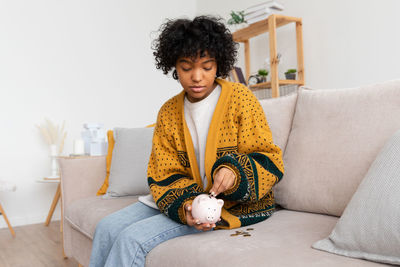 Young woman sitting on sofa at home