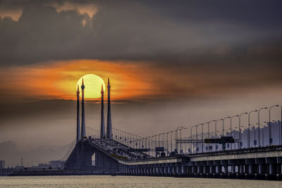 View of bridge against cloudy sky during sunset