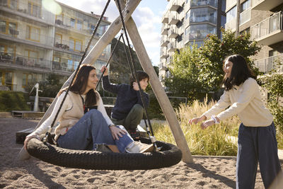 Mother with children on swing