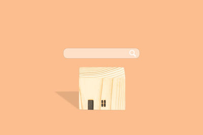 Close-up of electric lamp against orange wall