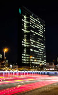 Light trails in city against sky at night