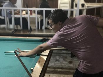Side view of man playing pool