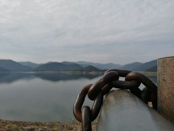 Close-up of chain on metal against lake