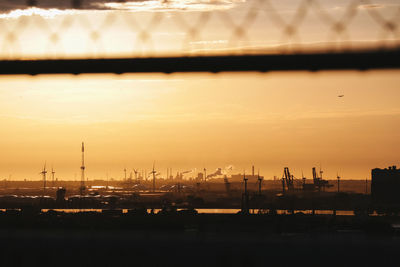 Scenic view of harbor against sky at sunset