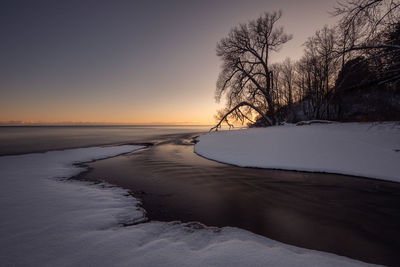 Scenic view of frozen lake against sky during sunset