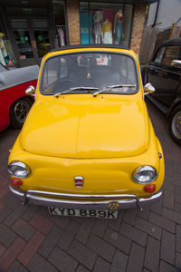 Yellow car parked on street in city