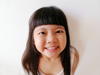 Portrait of smiling girl against white background