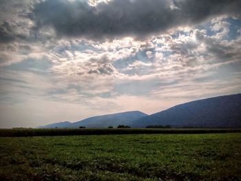 Scenic view of field and mountains against sky