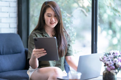 Young woman using digital tablet at home