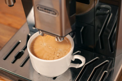 Espresso pouring from coffee machine, close up, professional coffee brewing.