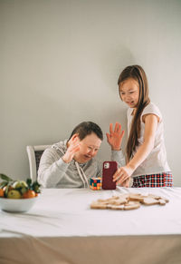 Asian girl helps elderly woman with down syndrome to call her family