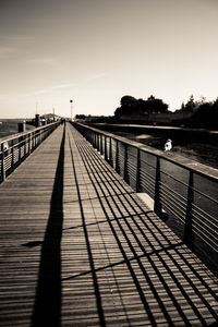 Boardwalk on beach against clear sky