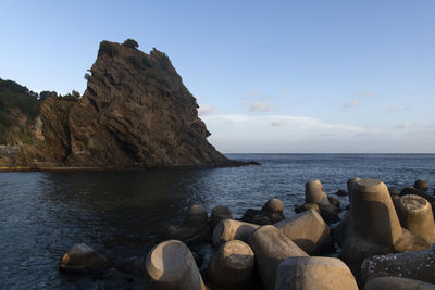 Rocks on sea shore against sky