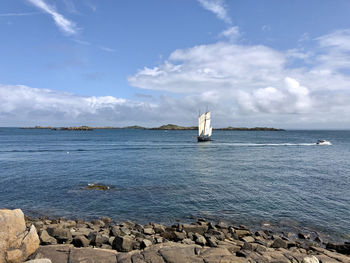 Sailboat on rock by sea against sky