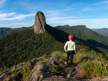 Rear view of man looking at mountain against sky