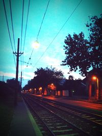 Railroad tracks against sky at sunset