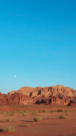 Scenic view of arid landscape against clear blue sky