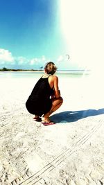 Rear view of woman sitting on beach