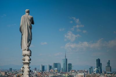 Statue of buildings against cloudy sky