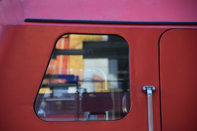 Window of red train with reflection