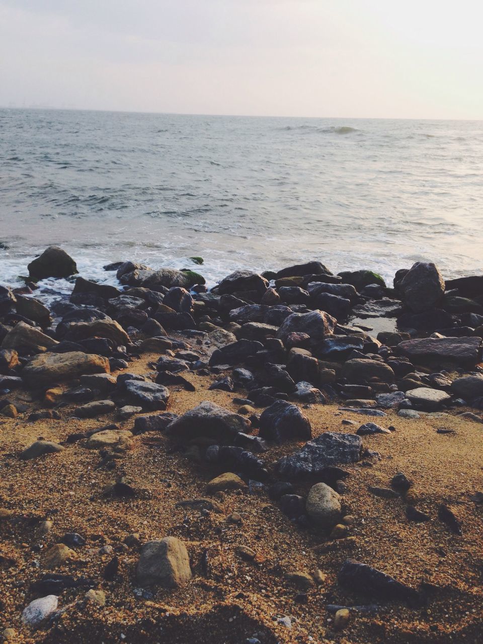 sea, beach, horizon over water, shore, water, sand, tranquility, tranquil scene, scenics, beauty in nature, nature, sky, wave, rock - object, pebble, stone - object, idyllic, coastline, clear sky, remote