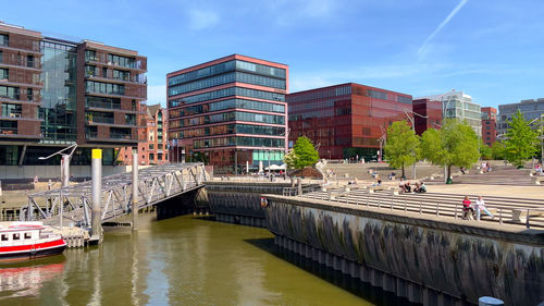 Bridge over river in city against sky