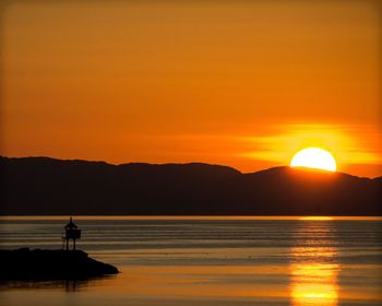 Scenic view of sea against orange sky