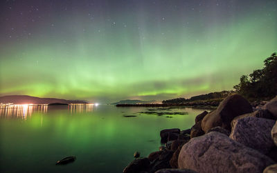 Scenic view of lake against sky at night