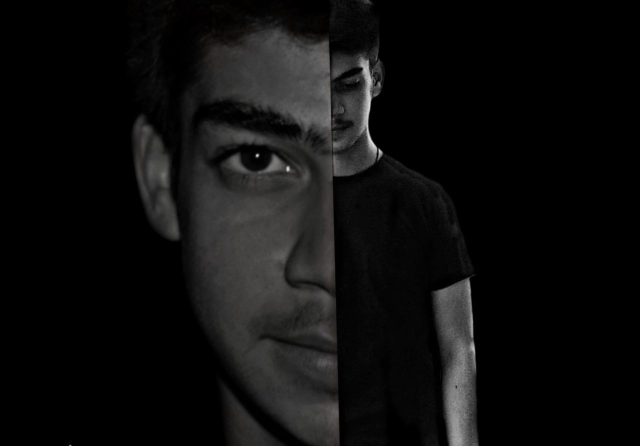 CLOSE-UP PORTRAIT OF YOUNG MAN WEARING BLACK BACKGROUND