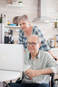 Senior couple using laptop on table at home