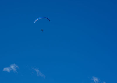 Low angle view of kite flying against blue sky