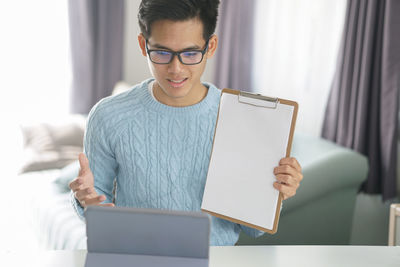 Young man using mobile phone at home