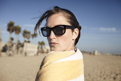 Portrait of young woman wrapped in towel on beach