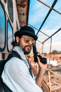 Portrait of young man holding hat