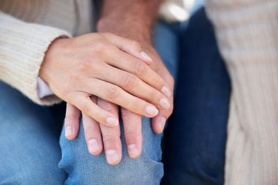 Midsection of couple holding hands