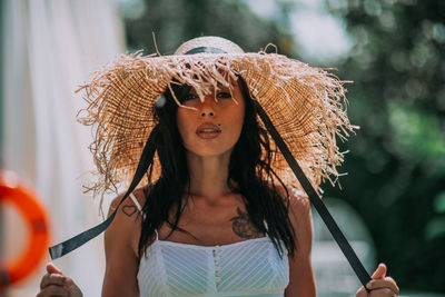 Portrait of woman wearing hat standing outdoors