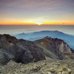 People sitting on summit mount rinjani at sunset