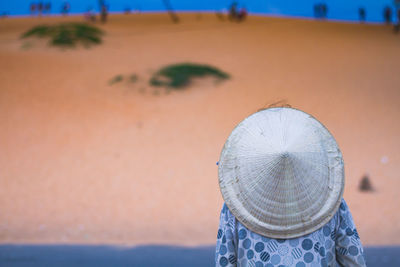 Rear view of woman wearing asian style conical hat