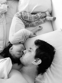 High angle view of father and daughter lying on bed at home