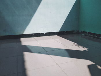 High angle view of shadow on tiled floor