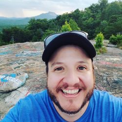 Portrait of smiling young man against trees