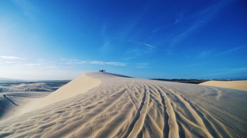 Scenic view of desert against blue sky