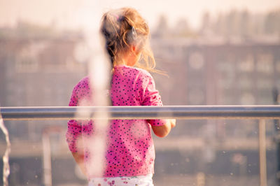 Water splashing against girl walking by railing