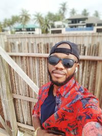 Portrait of young man wearing sunglasses standing outdoors