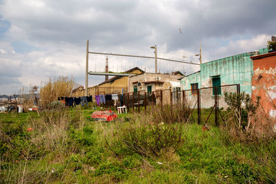 Abandoned house on field against sky